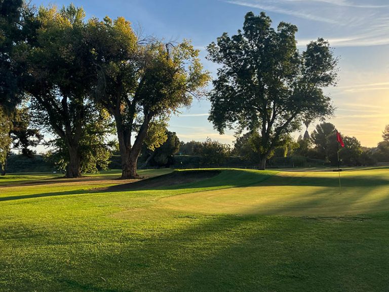 Sunset over a Lemoore Golf Course fairway with tee markers, trees, and golden Central California light.