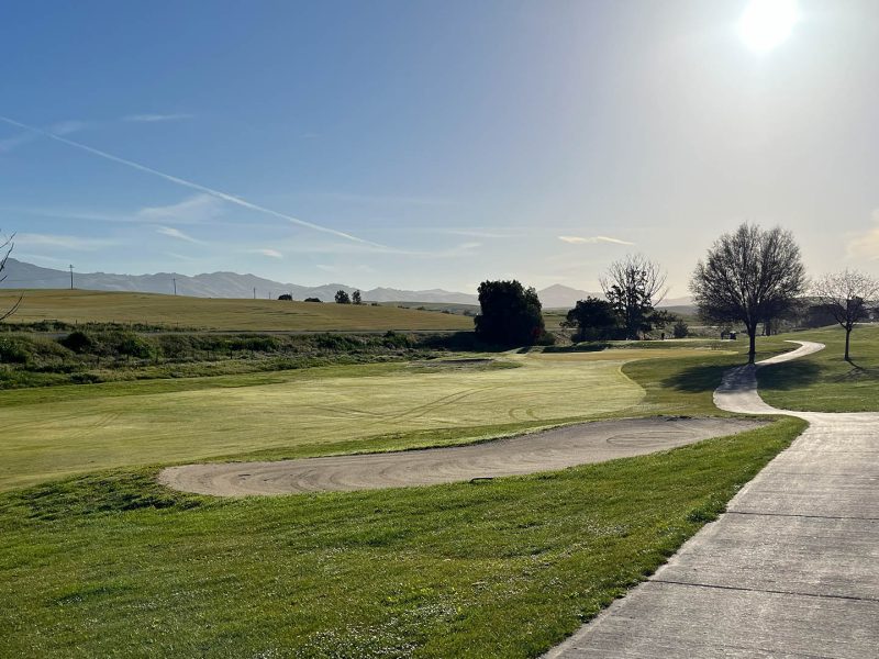 Fairway, sand bunker, and cart path at Ridgemark Golf Club & Resort with hills in the distance.