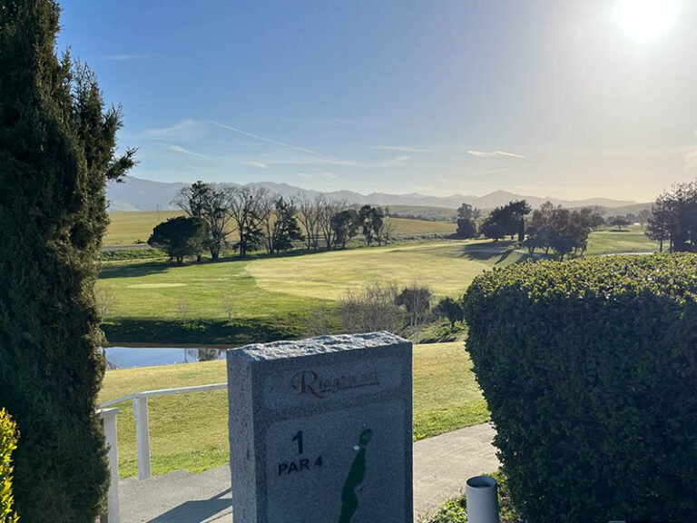 First hole marker at Ridgemark Golf Club & Resort overlooking a fairway, pond, and distant hills.