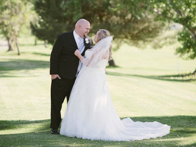 Bride and groom sharing a moment together on the golf course during wedding portraits.