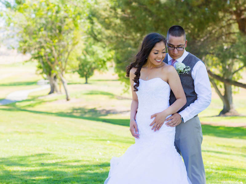 Bride and groom posing together for wedding portraits on the golf course at Ridgemark Golf Club & Resort.